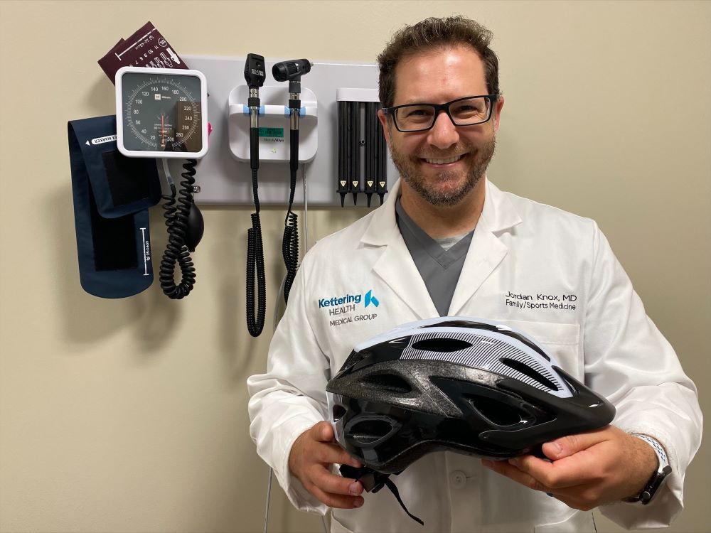 Dr. Jordan Knox holding a helmet